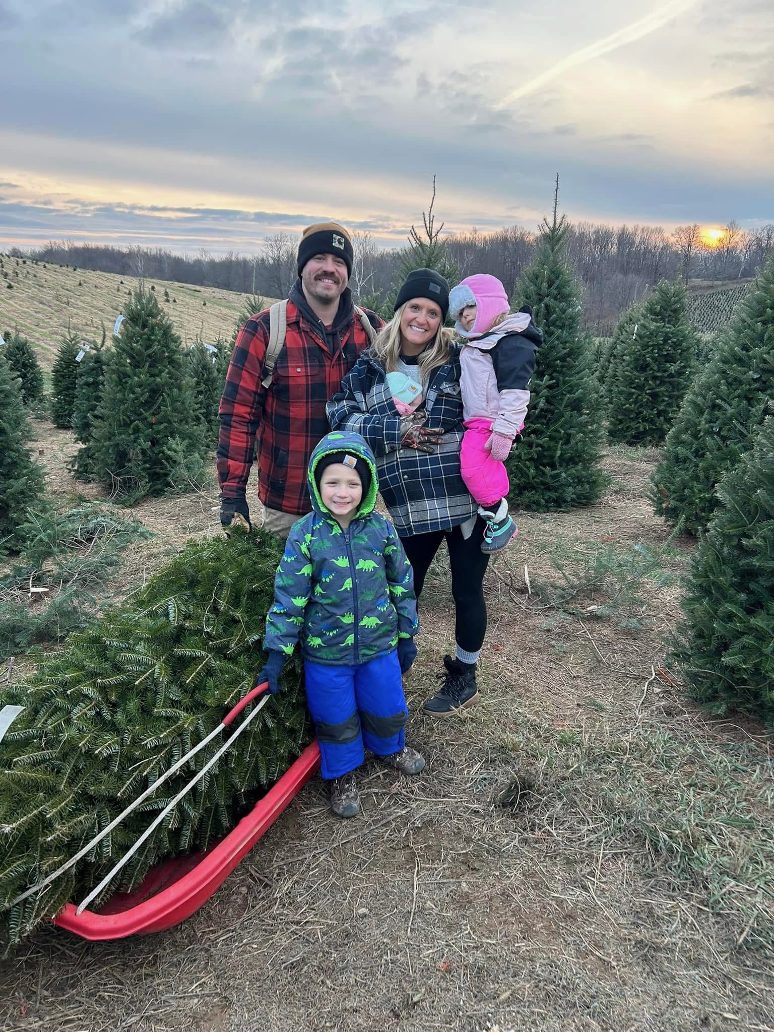 Tyler, Casey, and their kids at a tree farm.